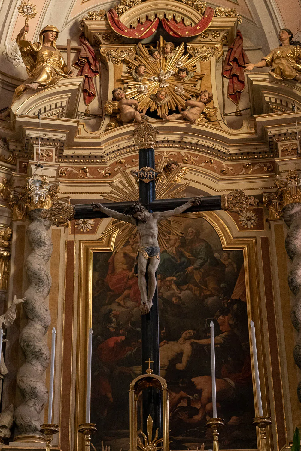 goldener barockaltar mit kreuzigungsbild und figürchen