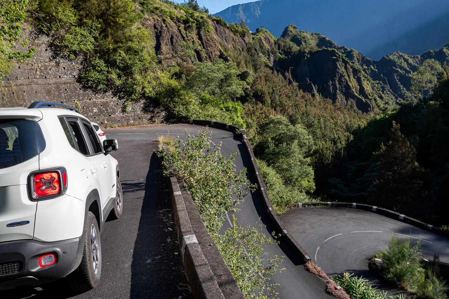 weißes auto auf serpentinstraße in berglandschaft