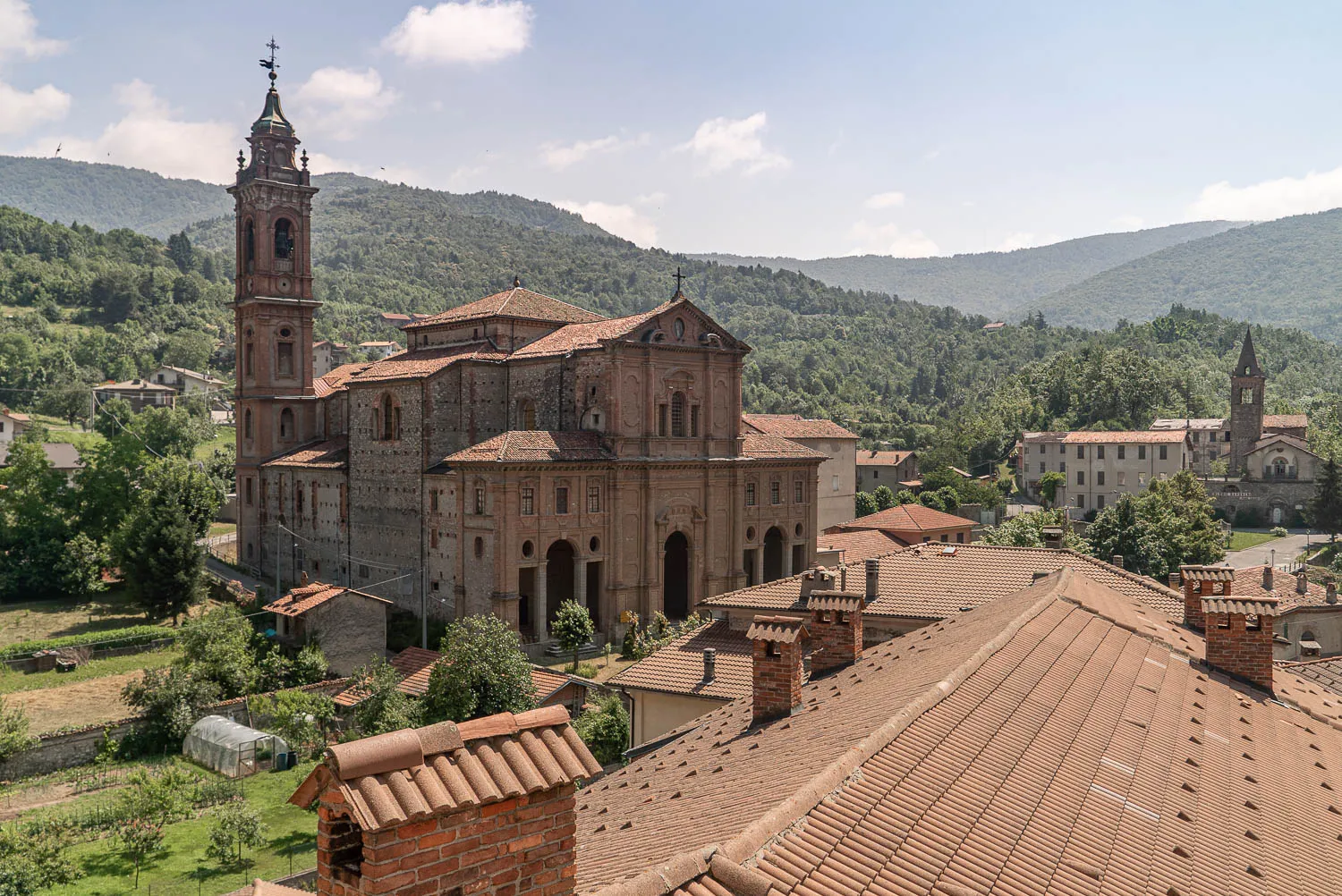 Kirche mit Turm in Garessio, umgeben von Bergen und Dächern