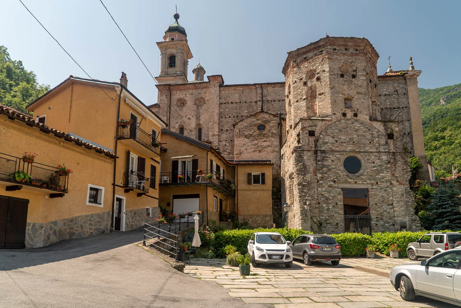 Steinbaukirche mit Turm und umliegenden Häusern in Garessio