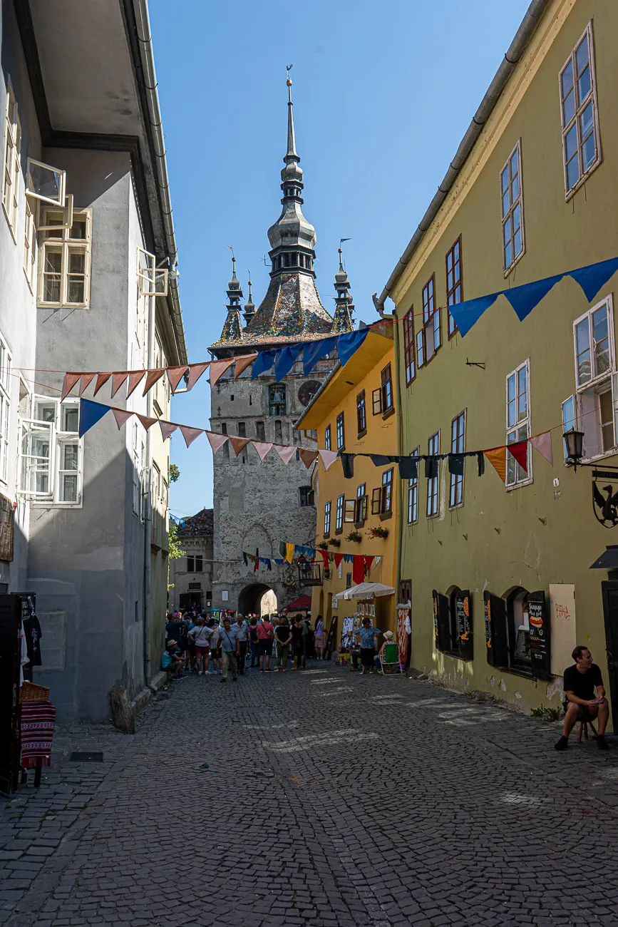 Gassen mit historischem Turm und bunten Girlanden zwischen Gebäuden