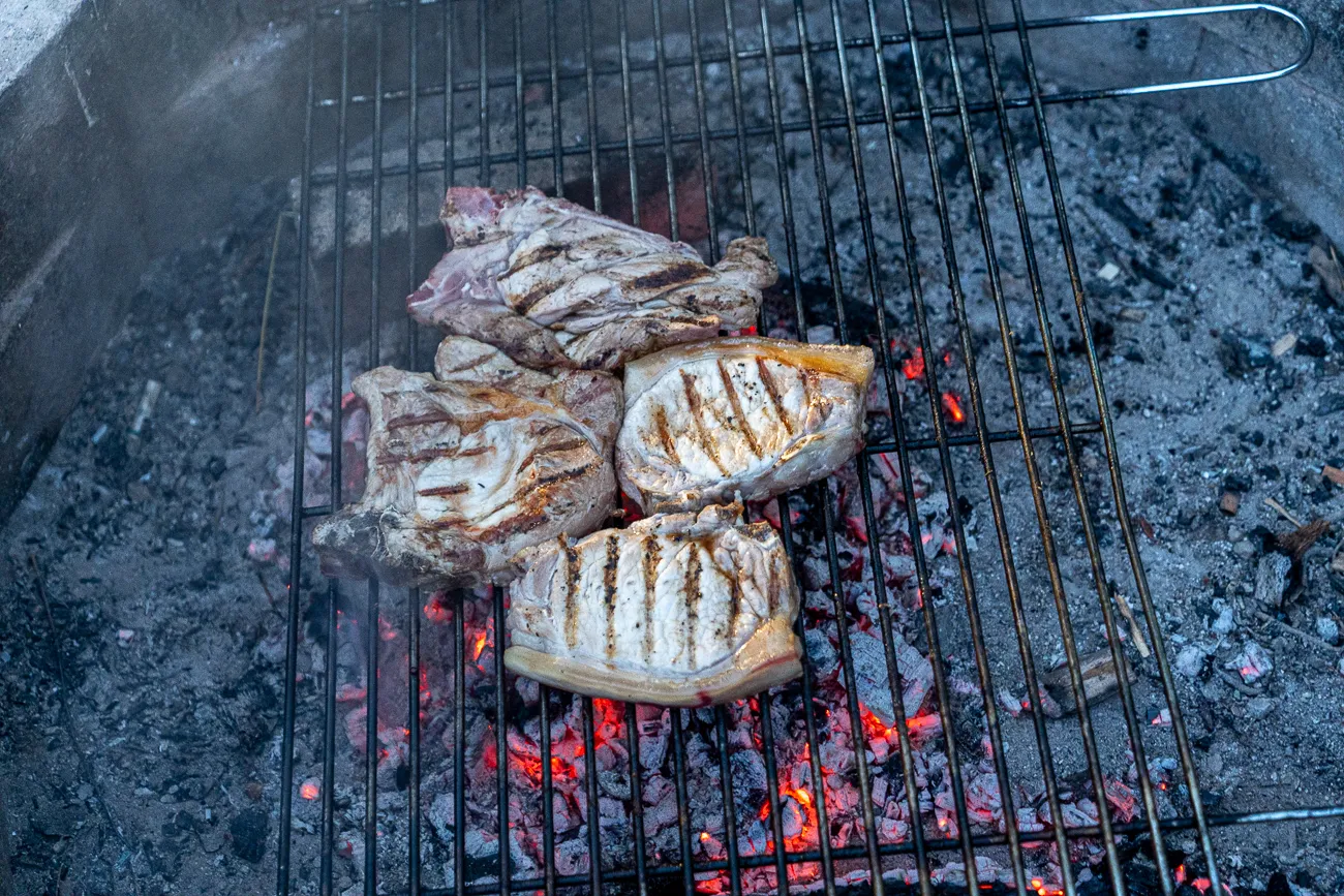 Gegrillte Fleischstücke auf einem Grillrost über glühenden Kohlen
