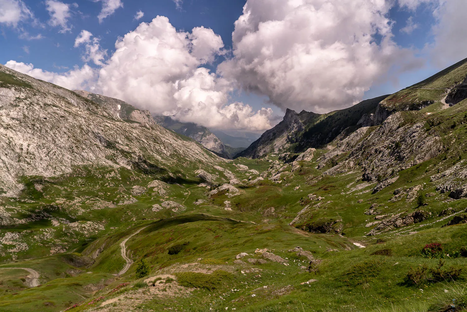 grüne berglandschaft mit steilen hängen und wolken