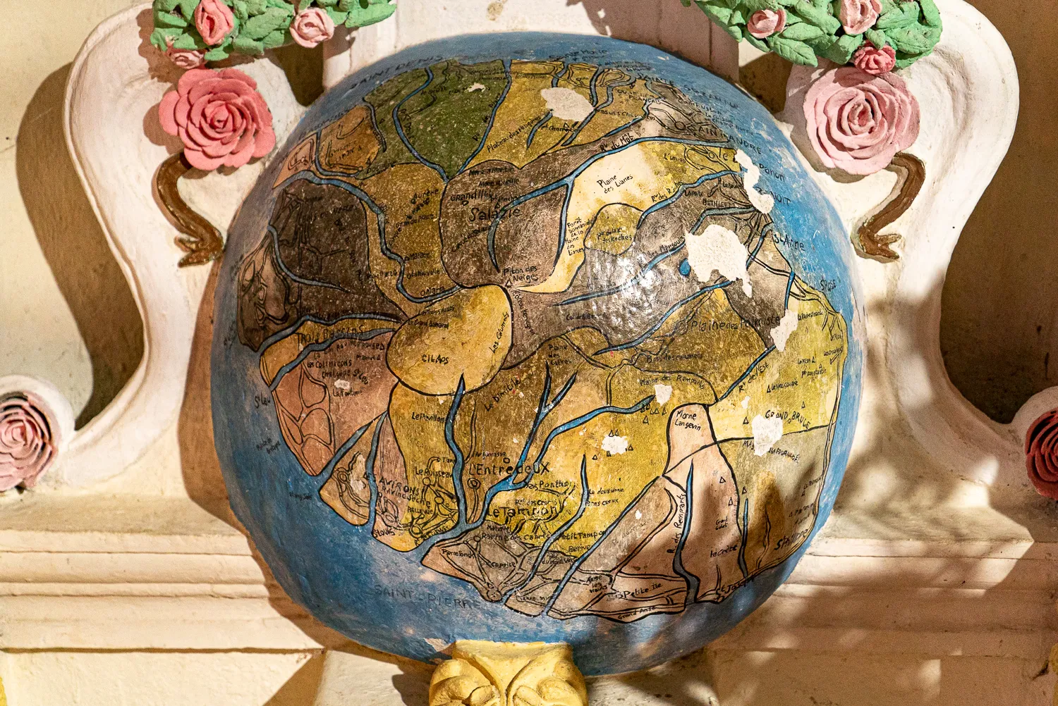 Handbemalter Globus mit Kontinenten und Flüssen, dekoriert mit rosa Rosen.