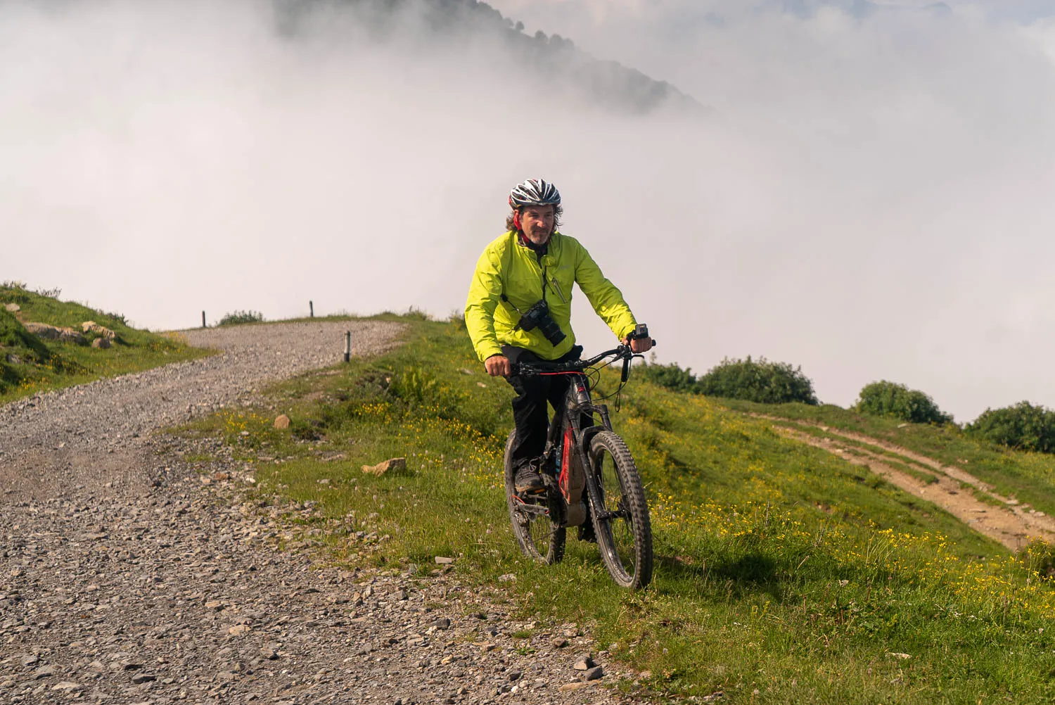Radfahrer fährt auf steinigem Pfad durch Nebel