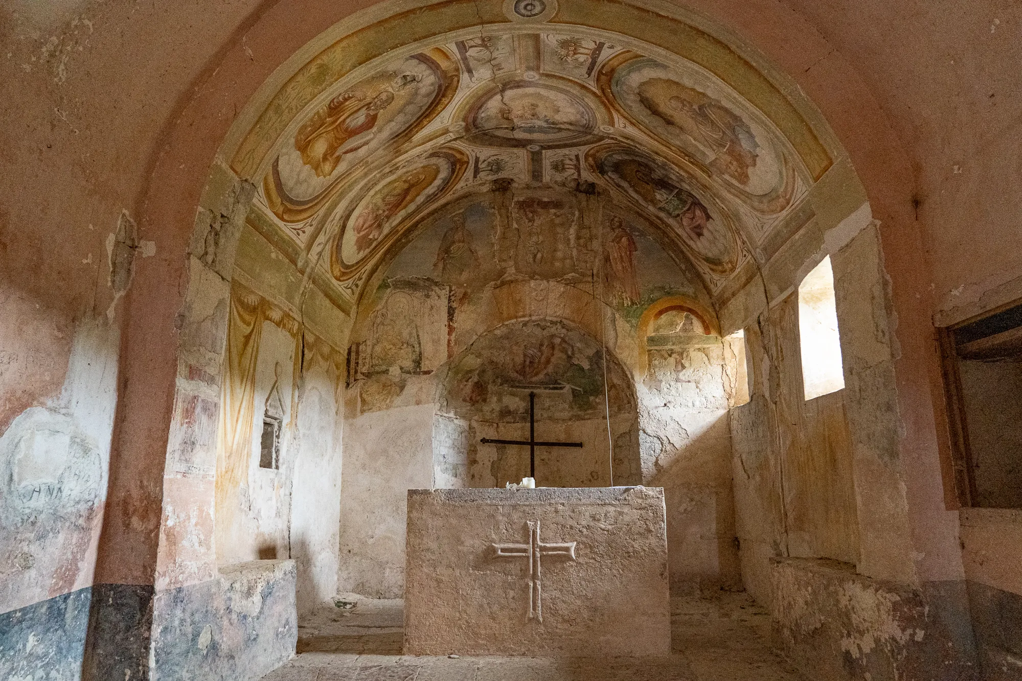 altar in alter kirche mit fresken an gewölbten wänden