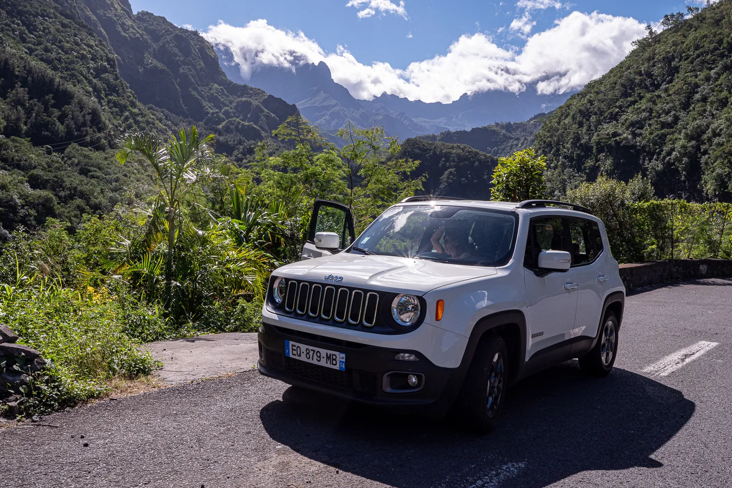 weißes jeep renegade auf kurvenreicher straße zwischen grünen bergen