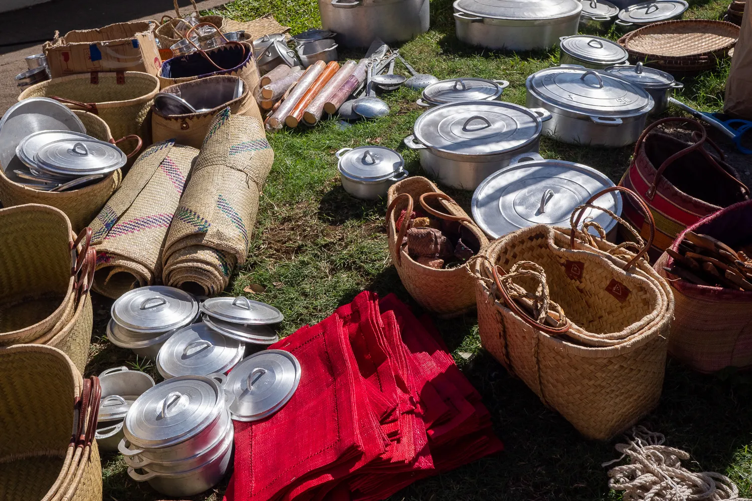 Marktstände mit Körben, Aluminiumtopfen und rotem Stoff auf Gras