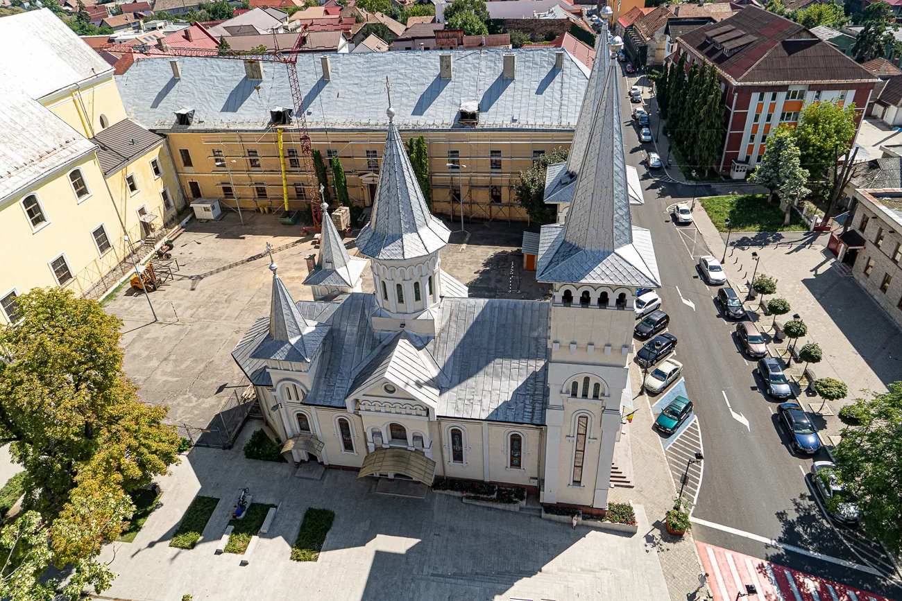 Luftbild einer weißen Kirche mit spitzen Türmen und umliegenden Gebäuden
