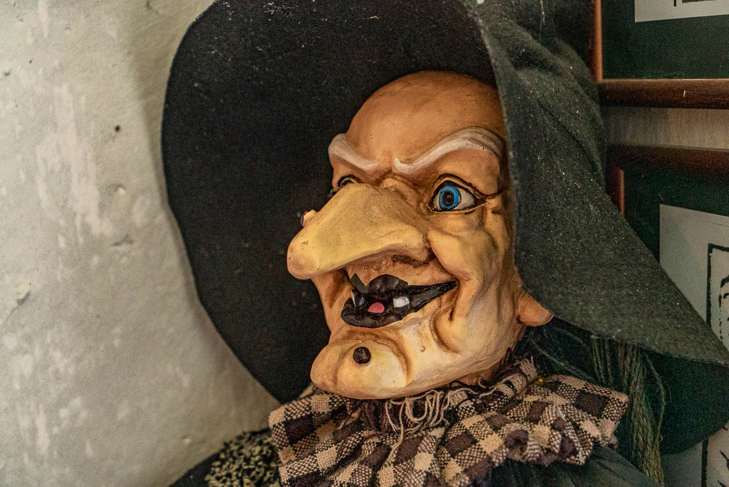 Maske einer Hexe mit breitem Grinsen und blauen Augen