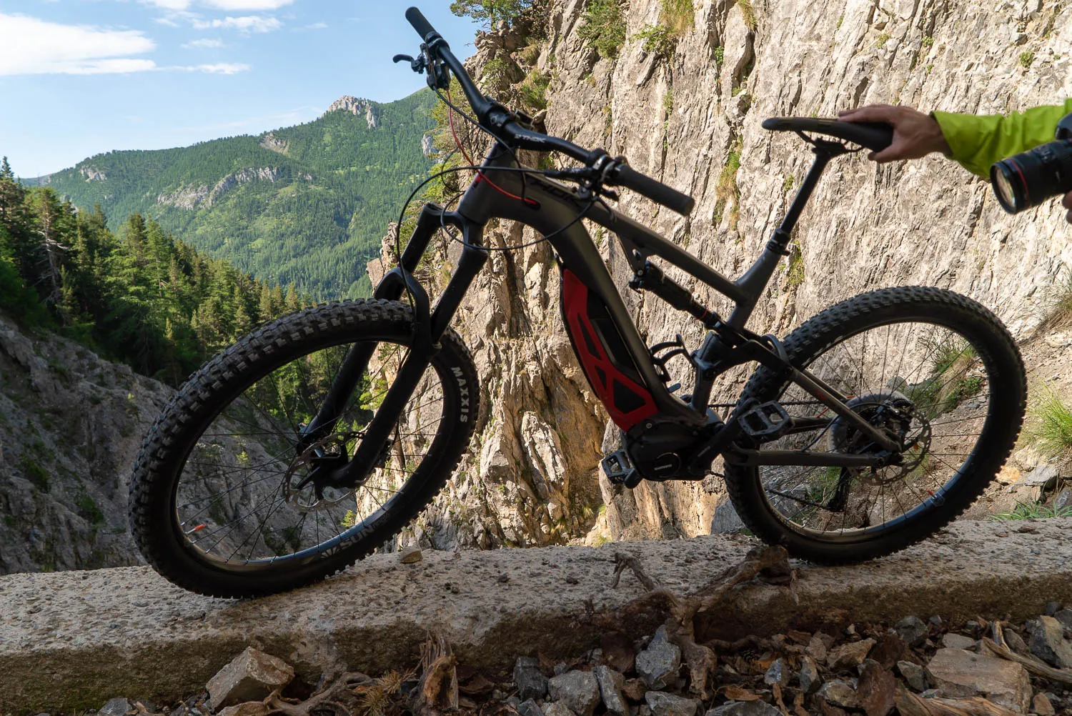 E-Bike auf Steinmauer vor Felswand mit Berglandschaft