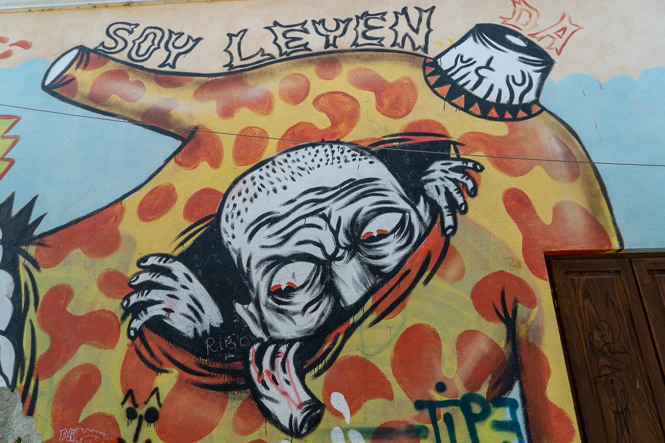Graffiti-Mural mit skurriler Figur und Schriftzug auf Wand