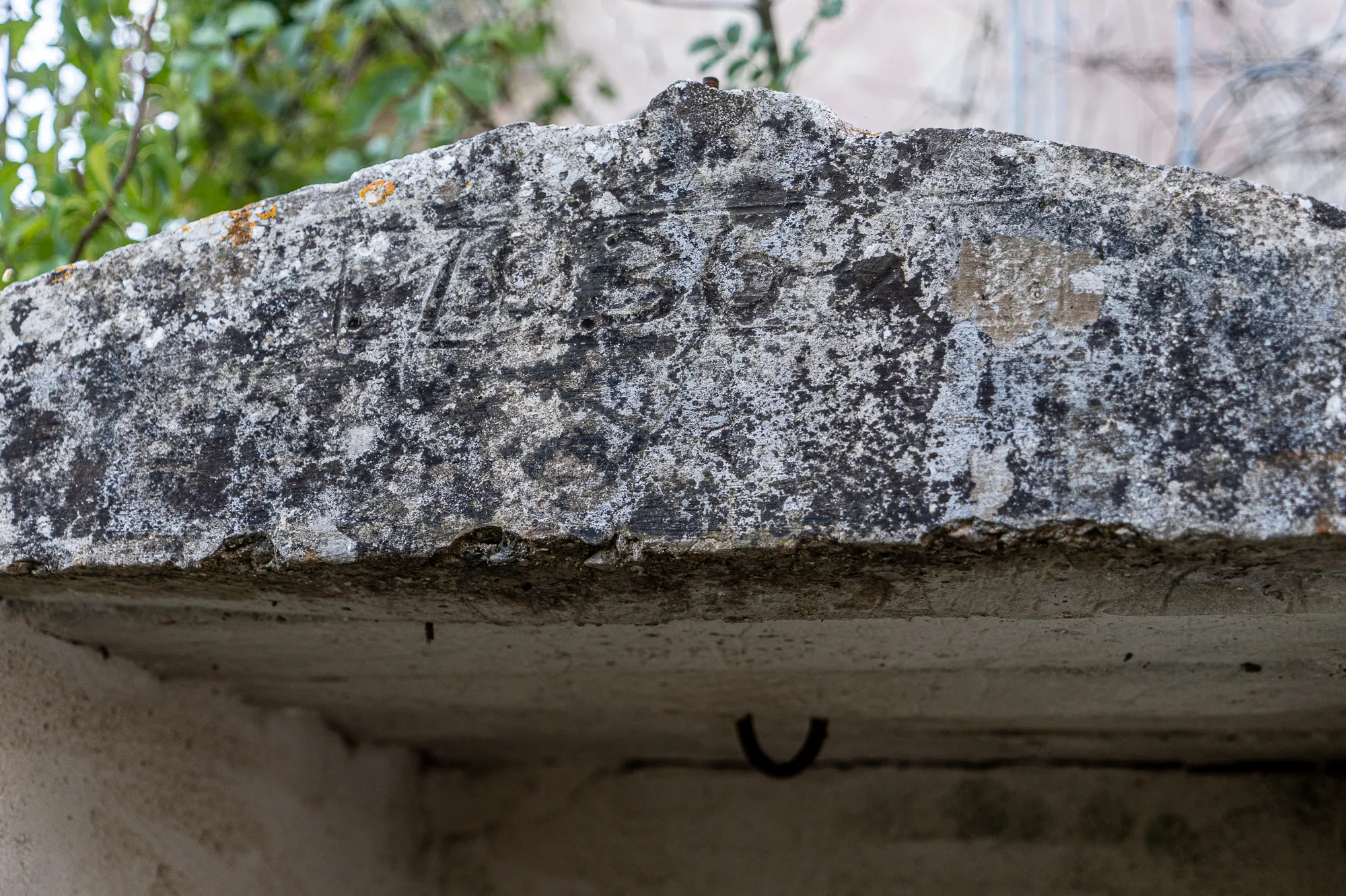 Alter Stein mit sichtbarer Jahreszahl 1936 und Moosbewuchs