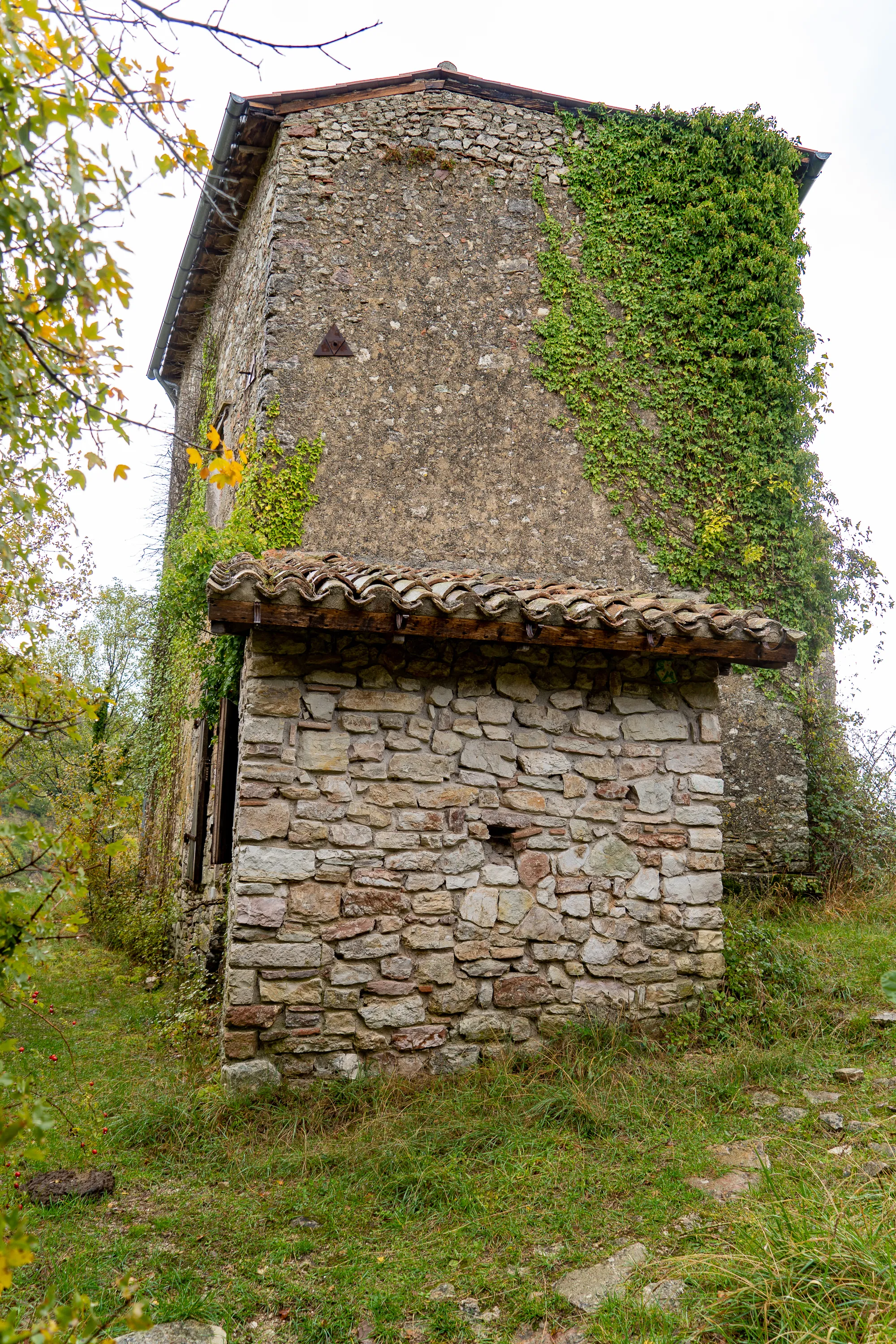 Steinbau mit Kletterpflanzen und Ziegeldach im Herbst