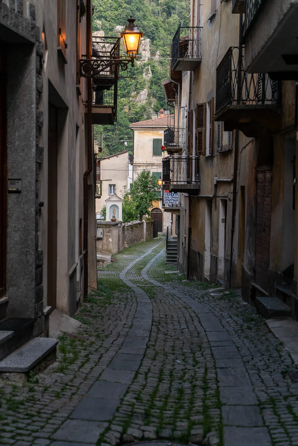 Gewundene Gasse mit Steinplatten und Gras zwischen den Steinen