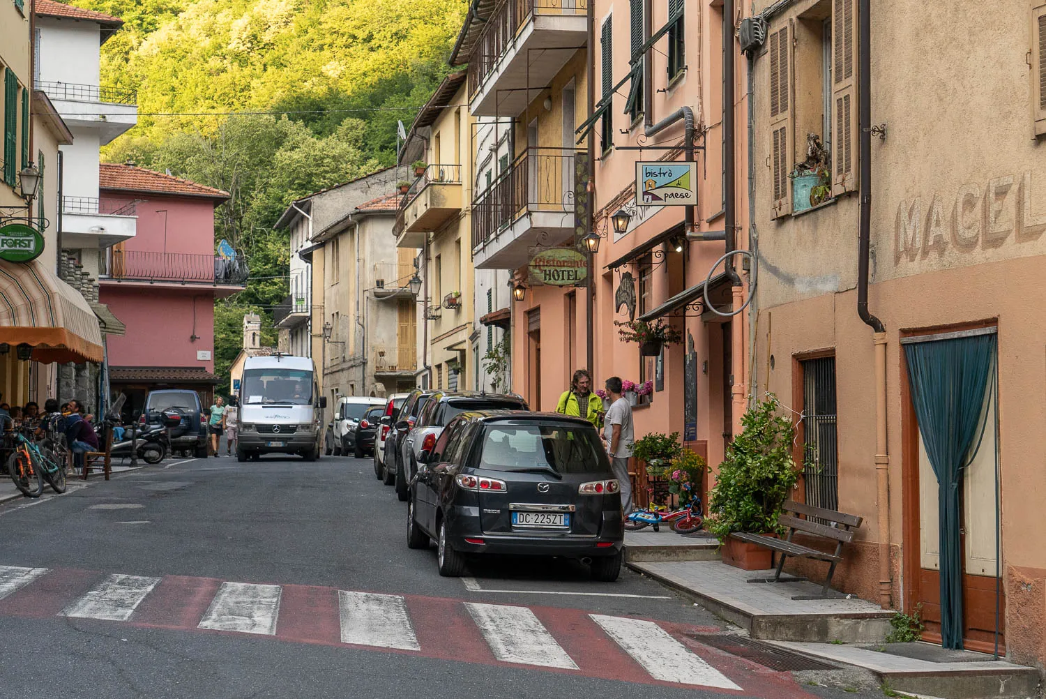 Straße mit geparkten Autos und Balkonen in Triora