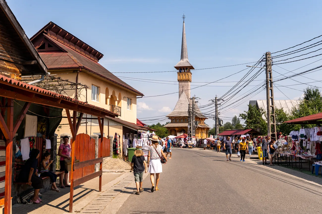 Marktstraße mit Holzkirche im Hintergrund und Passanten