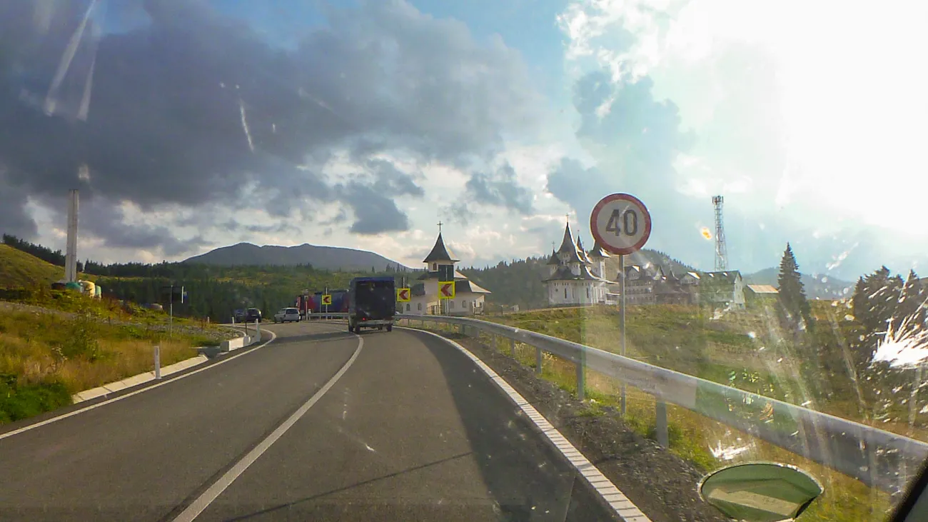 Straße mit Geschwindigkeitsbegrenzung 40, Kirche und Berge im Hintergrund