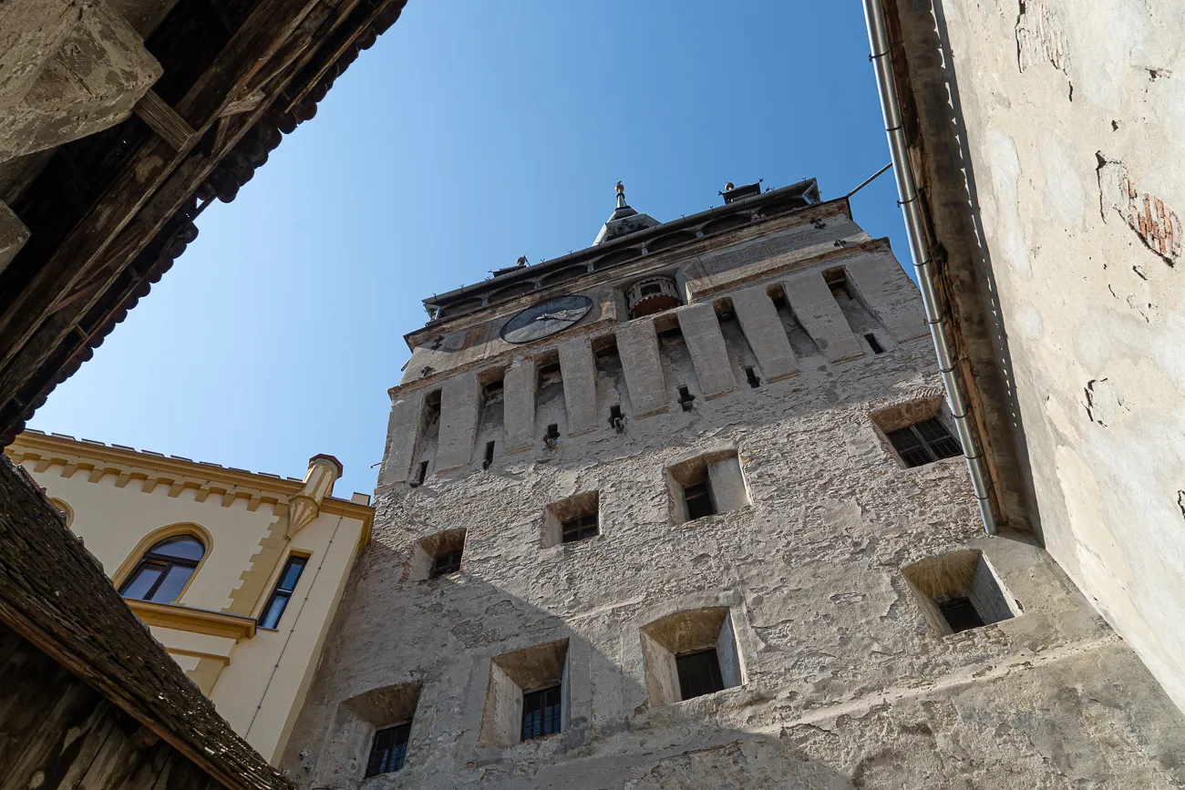 Alter steinerner Turm mit Uhr unter blauem Himmel