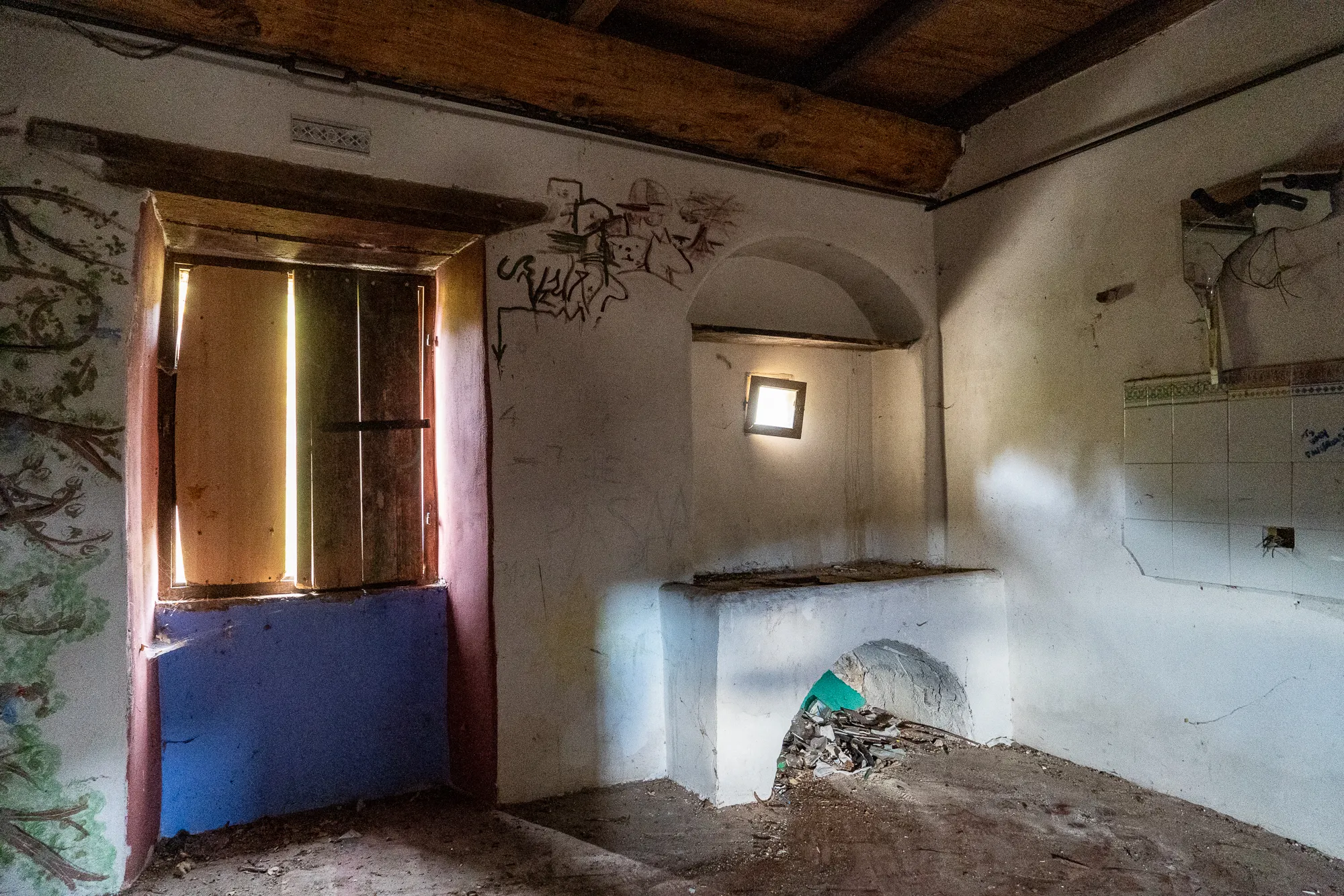 Verlassenes Zimmer mit Holzbalkendecke, Fenster und Wandmalereien