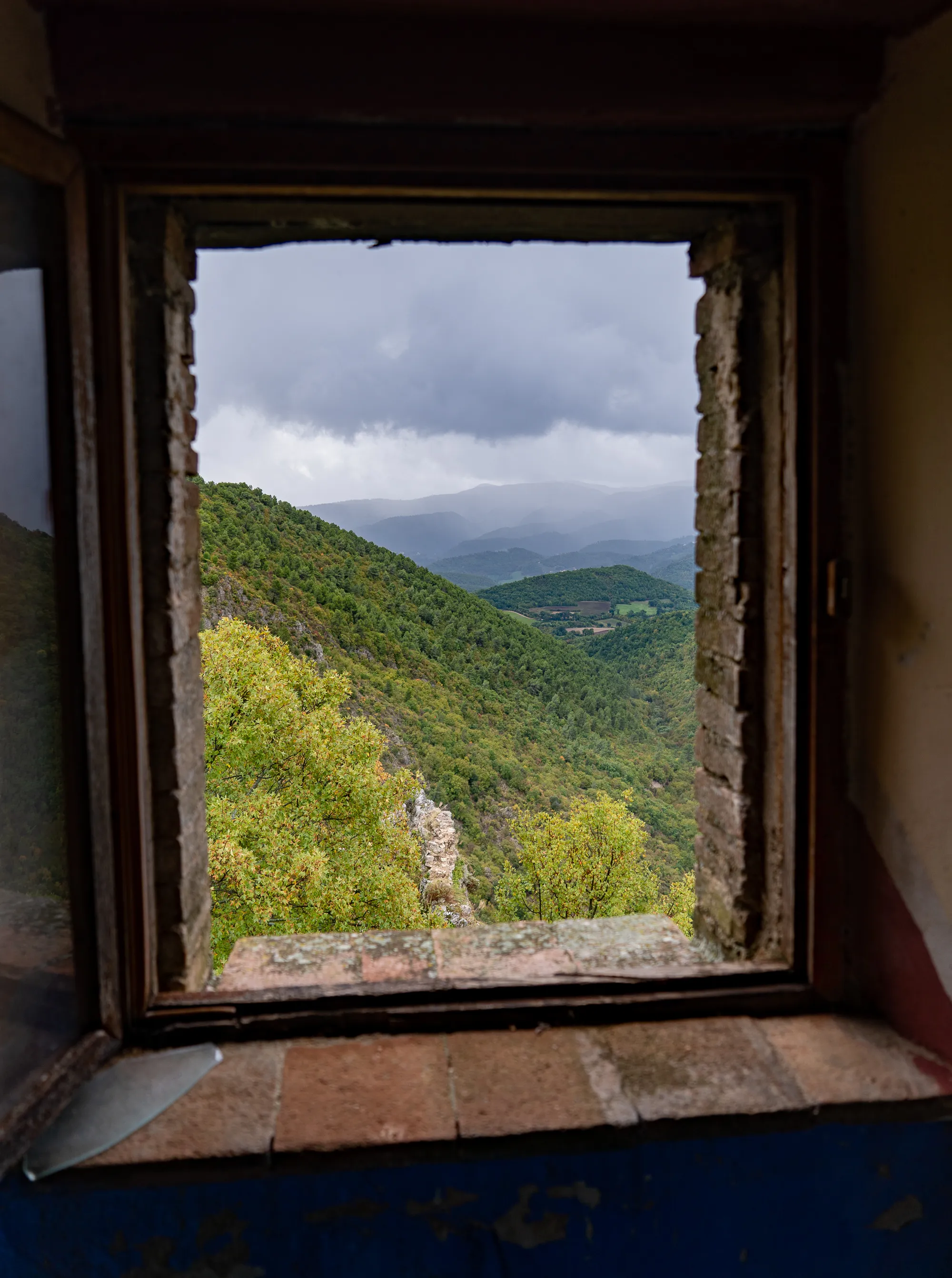 altersbedingt verwittertes fenster mit berglandschaft im hintergrund