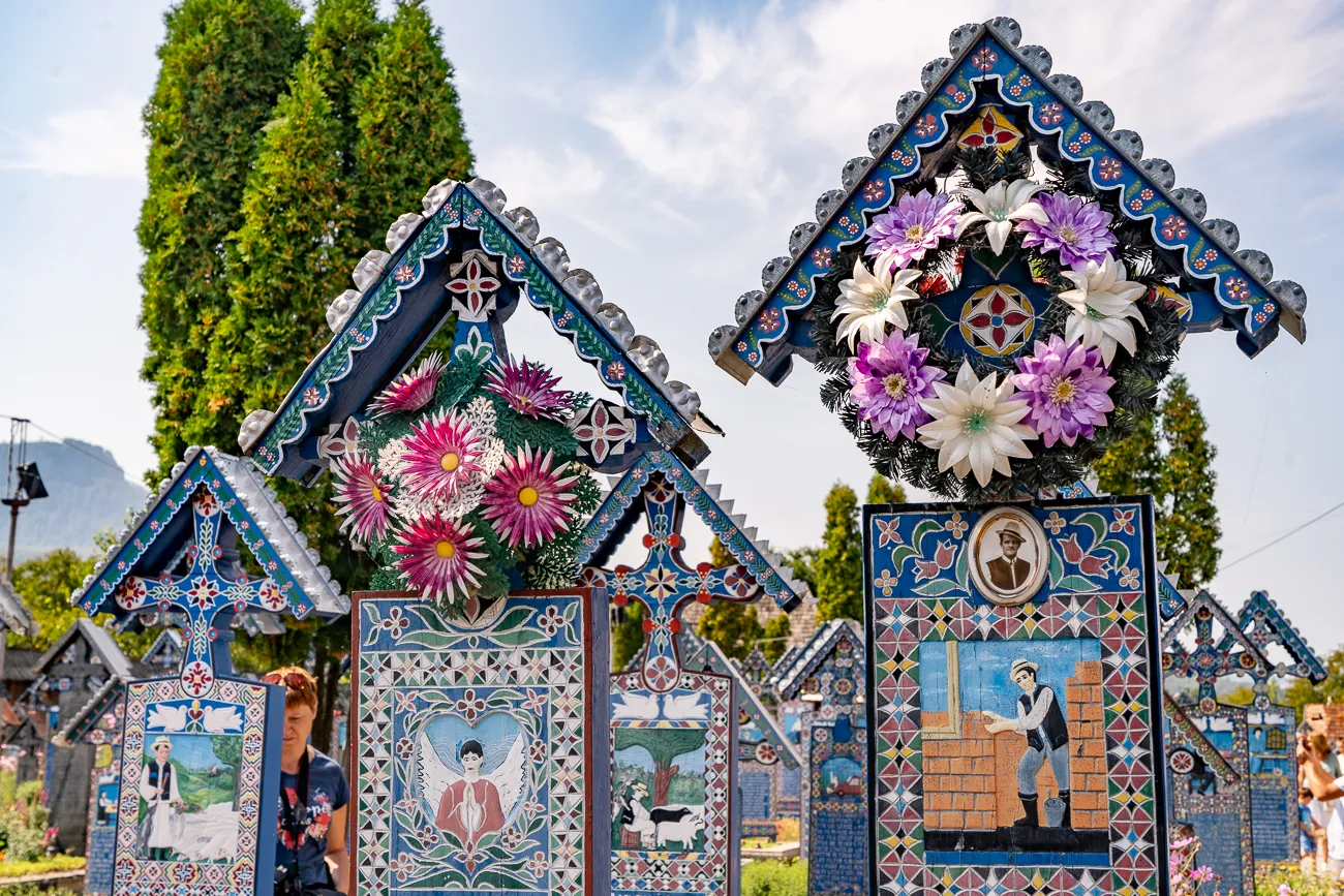 Farbenfrohe, kunstvoll verzierte Grabmale mit Blumen und Bildern im Freien.