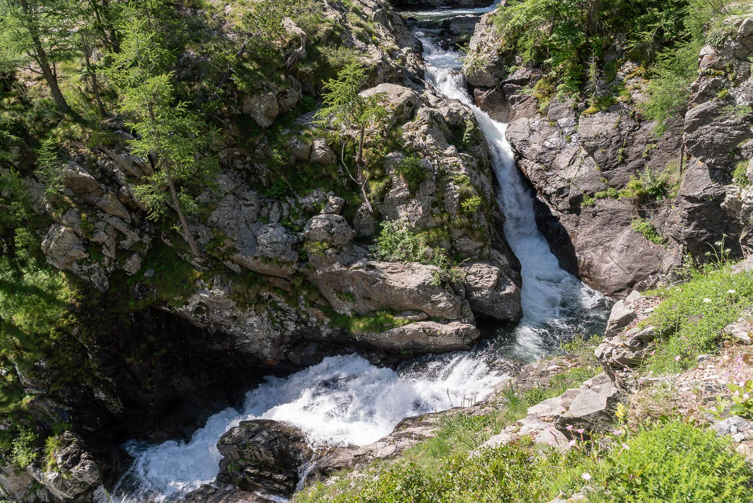 Wasserfall in einem felsigen Tal mit grüner Vegetation